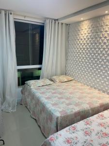 ein Schlafzimmer mit zwei Betten und einem Fenster in der Unterkunft Apartamento Duplex - a 3 min da Praia apé, Próximo Axé Moi e ToaToa in Porto Seguro