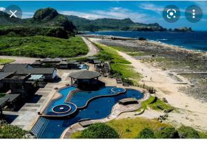 een resort met een zwembad naast een strand bij 花田綠島 in Green Island