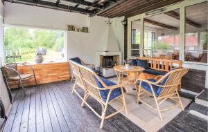 een veranda met een tafel en stoelen en een open haard bij Pet Friendly Home In Hstveda With Wifi in Hästveda