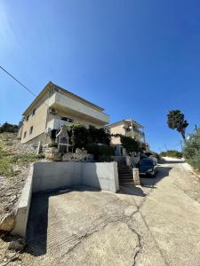 una casa con un'auto parcheggiata davanti di Apartments Veli Rat a Veli Rat