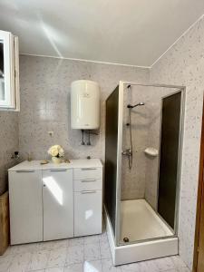 un bagno bianco con doccia e lavandino di Apartments Veli Rat a Veli Rat