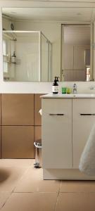 a white kitchen with a sink and a mirror at Cara in Daylesford