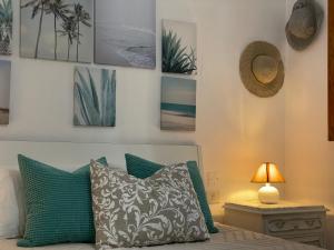 a bedroom with a bed with green pillows and pictures on the wall at Casa El Conde in Agaete