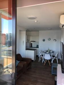 a living room and kitchen with a couch and a table at Tindy’s City Pad in Adelaide