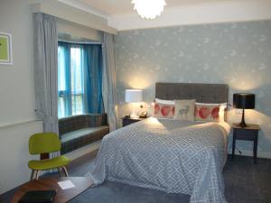 una camera con letto, sedia e divano di Coulsdon Manor Hotel and Golf Club a Croydon