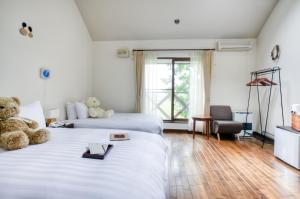 um quarto de hotel com duas camas com ursos de peluche em Adagio Hokkaido em Biei