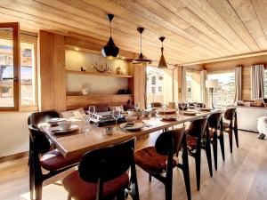 Un comedor con una mesa larga y sillas. en Chalet de luxe avec sauna et jacuzzi, à 200m des pistes - FR-1-344-1151, en Praranger