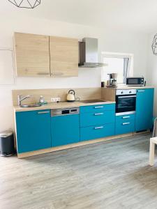 - une cuisine avec des placards bleus et un évier dans l'établissement Larimar Apartment Kirchheim am Neckar, à Kirchheim am Neckar