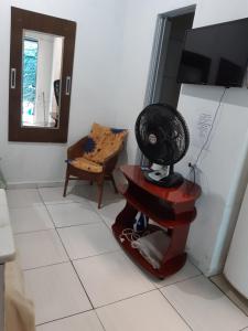 Habitación con espejo y ventilador en una mesa. en Kitnet Aconchegante Em Benfica, en Río de Janeiro