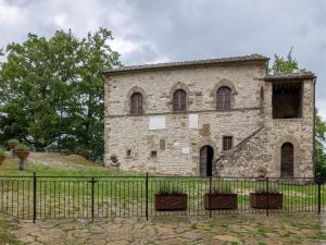 an old stone building with a black fence at Historic farmhouse in Caprese Michelangelo with Pool in Caprese Michelangelo