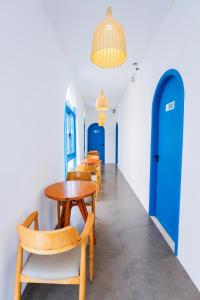 un pasillo con mesas, sillas y puertas azules en Tò Vò Hostel Huế, en Hue