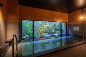 a swimming pool in a room with a large window at Hotel Route Inn Shikoku Chuo in Shikokuchuo