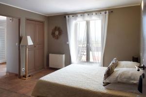 a bedroom with a large bed and a window at l'Hotellerie Kouros in Cuers