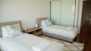 a bedroom with two beds and a mirror at Bridgepoint 103 in Mandurah