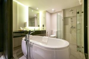 a bathroom with a tub and a toilet and a sink at S Ratchada Leisure Hotel - SHA PLUS in Bangkok