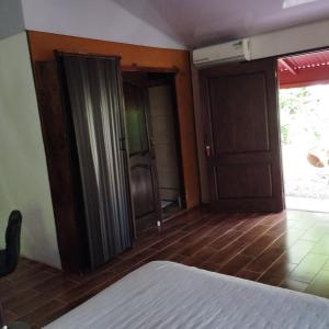 ein Schlafzimmer mit einem Bett und zwei offenen Türen in der Unterkunft Casa Sol in Sarapiquí