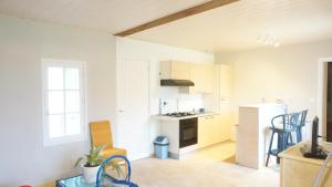 a kitchen with white cabinets and a stove top oven at Gite Le Verger in Commes