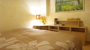 a bedroom with a bed and a desk and a painting at Gite Le Verger in Commes