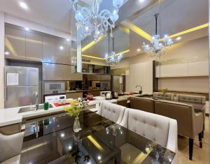 une cuisine avec un comptoir en verre, des chaises et des lustres dans l'établissement Nana's at Dorsett Residence Bukit Bintang, à Kuala Lumpur