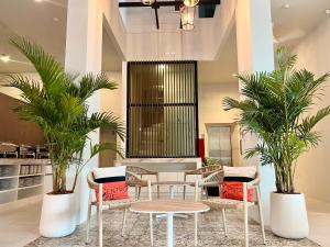 a lobby with a table and chairs and palm trees at Centro One Patong in Patong Beach