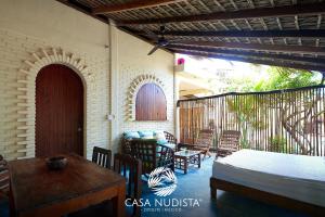 a room with a bed and a table and chairs at Casa Nudista - LGBT Hotel in Zipolite