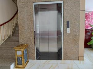 a metal elevator in a building with a staircase at Victoria Phu Quoc hotel Beachfront Night market in Phú Quốc