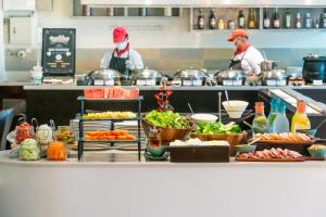 two chefs in a kitchen with food on a counter at Park Plaza Sukhumvit Bangkok in Bangkok