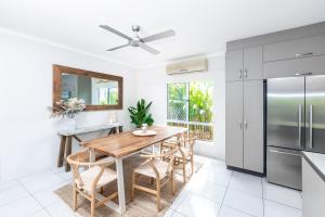 eine Küche mit einem Holztisch und einem Kühlschrank in der Unterkunft Mango Wood Villa Tropical Coastal living in Clifton Beach