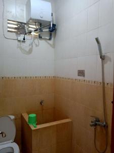 a bathroom with a tub and a toilet and a shower at RedDoorz @ Puncak Tahura Hotel Bengkulu Tengah in Bengkulu