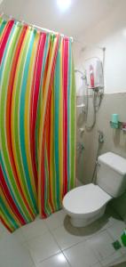 y baño con cortina de ducha colorida y aseo. en Amor's Place en Puerto Princesa