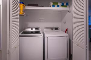 a small kitchen with a stove and a washer and dryer at Mauna Ua in Volcano