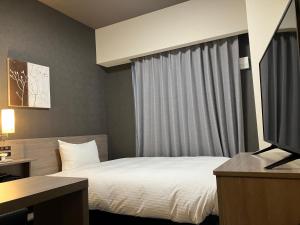 Postel nebo postele na pokoji v ubytování Hotel Route Inn Shikoku Chuo
