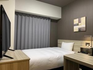 Postel nebo postele na pokoji v ubytování Hotel Route Inn Shikoku Chuo