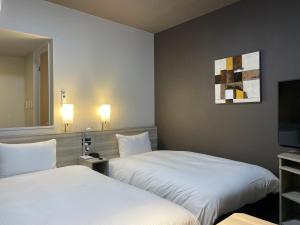 Postel nebo postele na pokoji v ubytování Hotel Route Inn Shikoku Chuo