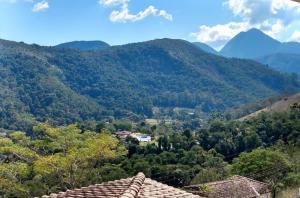 uma vista para um vale com montanhas ao fundo em Pousada Quinta do Alto em Itaipava