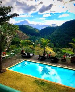 a swimming pool with a view of a mountain at Pousada Quinta do Alto in Itaipava