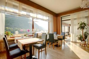 a dining room with a table and chairs and a large window at Hotel Haus Erholung in Cochem