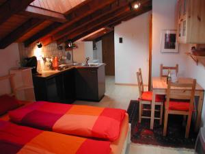 1 dormitorio con cama, mesa y cocina en Haus Arbgrat, en Zermatt