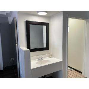uma casa de banho com um lavatório branco e um espelho. em Oak Tree Inn em Los Angeles