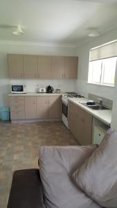 a kitchen with a couch in the middle of it at Port Waikato Holiday Park in Port Waikato