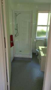 ein Bad mit einer Dusche, einem WC und einem Waschbecken in der Unterkunft Port Waikato Holiday Park in Port Waikato