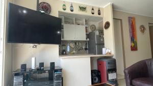 sala de estar con TV de pantalla plana en la pared en Cuatro Esquinas de Italia en La Serena