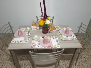 stół z krzesłami i stół z różowymi potrawami w obiekcie Casa Vacanza Orto dei Preti w mieście Collepardo