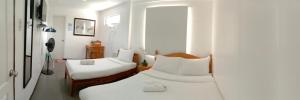 1 dormitorio con 2 camas y ventana en Amor's Place en Puerto Princesa