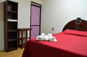 - une chambre avec un lit rouge et une couette rouge dans l'établissement Hotel Casa Genesis, à Oaxaca