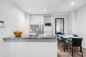 a kitchen and dining room with a table and chairs at Astral Apartments. Spacious 2 bed, 2 bath apartment in a great location. in Melbourne