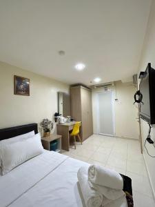 a bedroom with a bed and a television and a desk at Noor Hotel Kangar in Kangar
