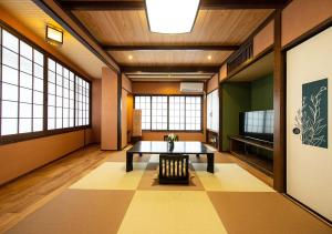 a large room with a table and a television at Ryokan Kiraku in Beppu