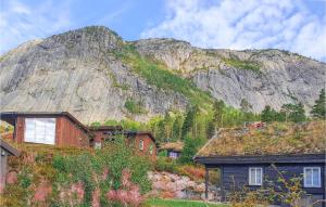a mountain with a bunch of houses in front of it at Gorgeous Home In Rysstad With House A Mountain View in Rysstad