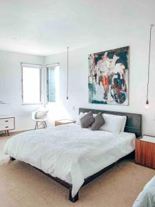 een slaapkamer met een groot bed en een schilderij aan de muur bij Modern house close to CBD & Adelaide Oval in Prospect